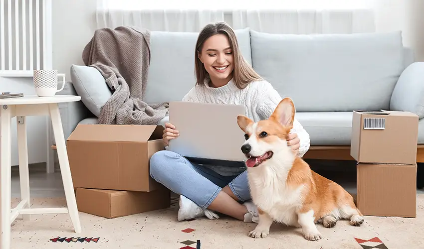 Girl with laptop and dog next to her